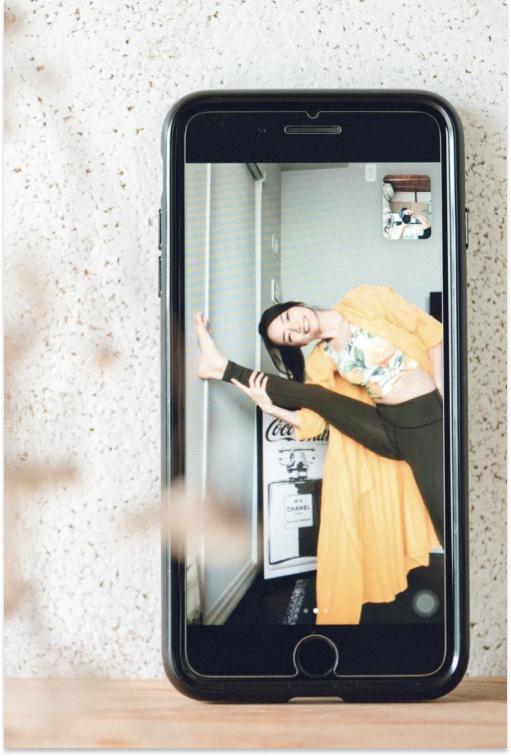 スマートフォン画面上に映るヨガをする女性